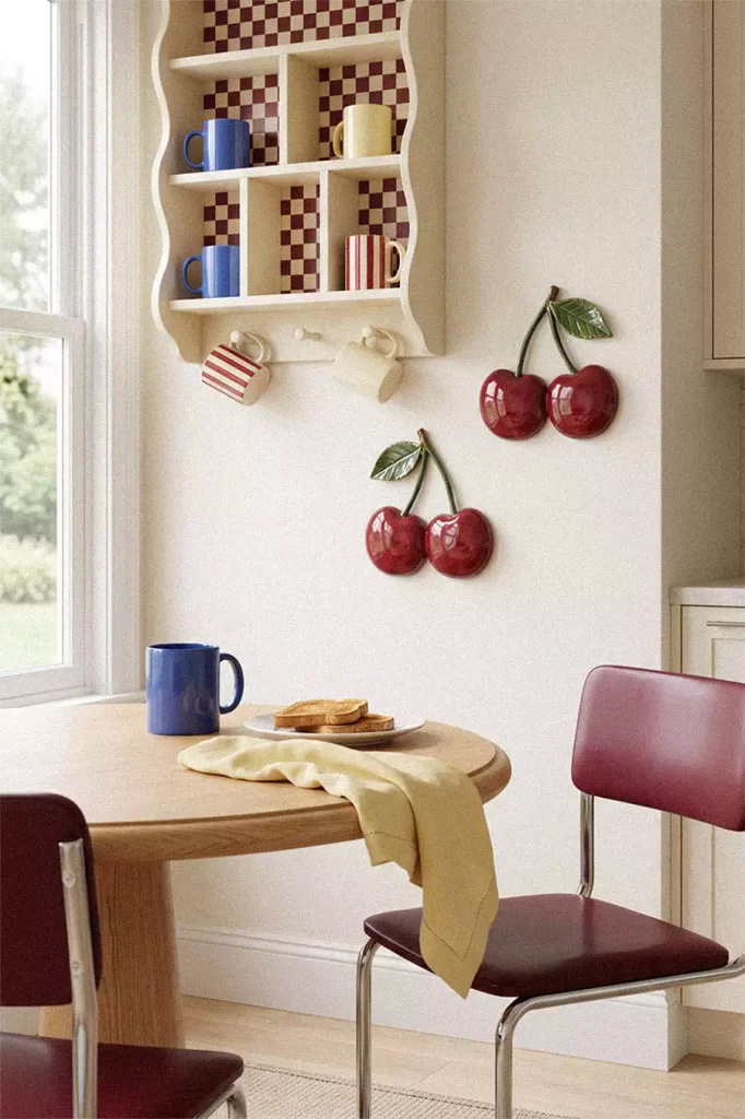Glossy red cherry wall decorations beside a checkerboard mug shelf in a breakfast nook