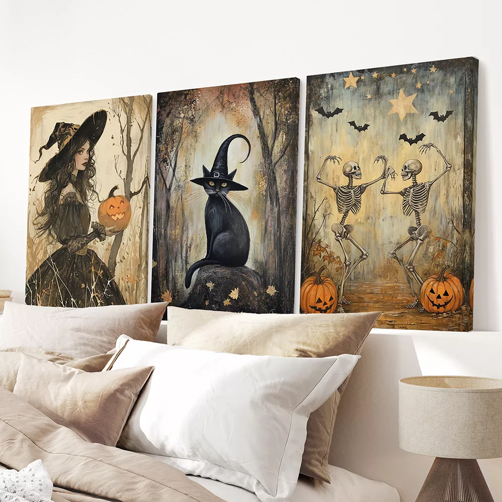 Halloween wall decor with three canvas prints of a witch, a black cat in a witch hat, and dancing skeletons above a neutral bed