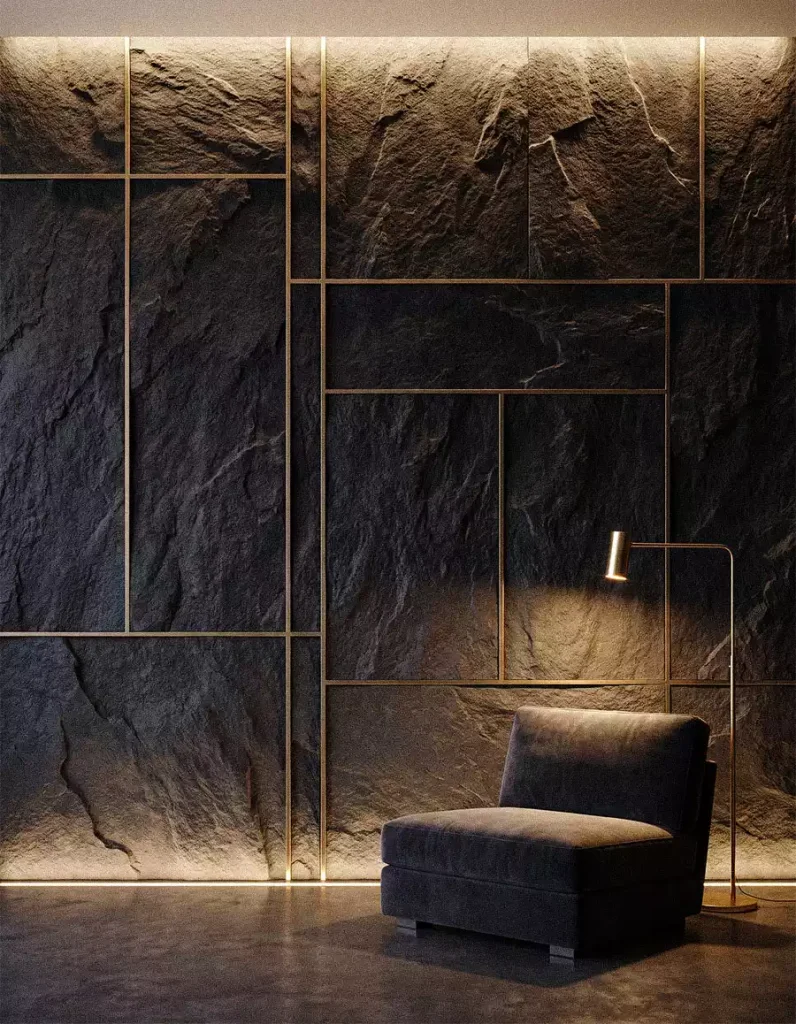 Large rough dark stone wall panels separated by thin metallic lines behind a lounge chair