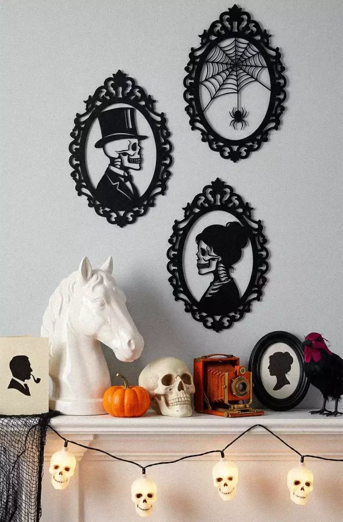 Ornate black frames containing skeleton portraits and a spiderweb above a mantel hung with glowing skull lights