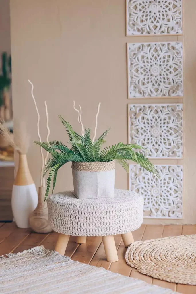 White carved decorative panels arranged vertically behind a potted fern